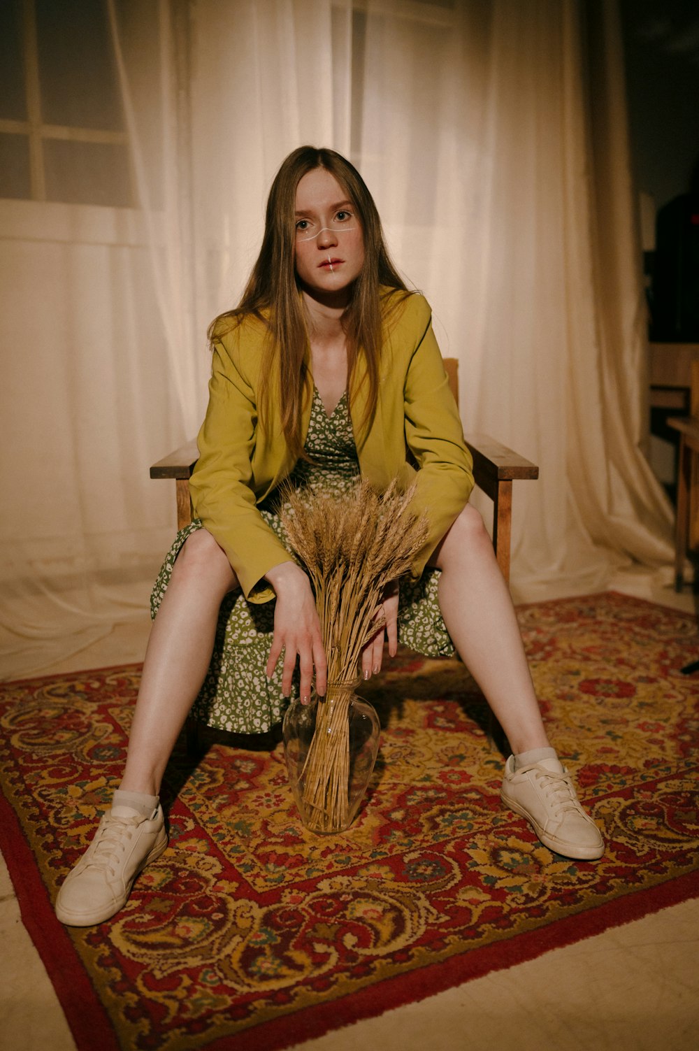 woman in yellow long sleeve dress sitting on brown and white floral sofa