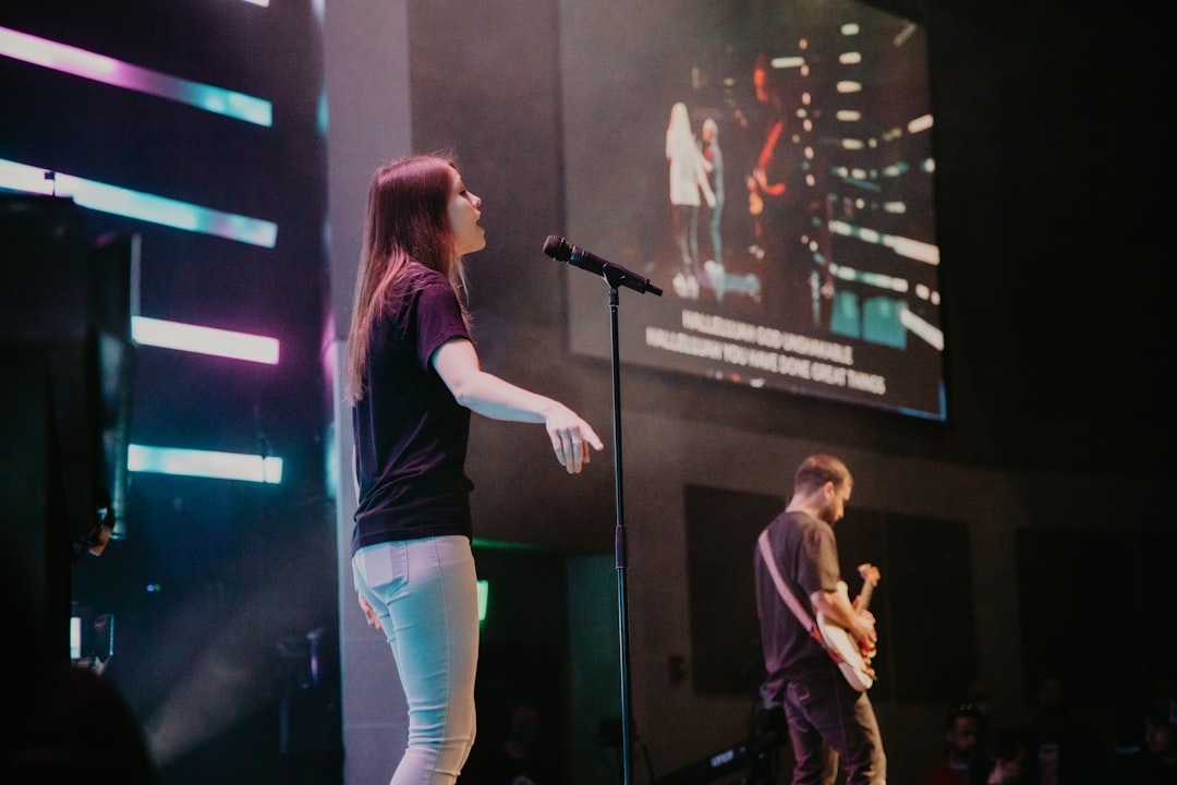 woman in black shirt singing on stage