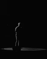 A close-up vertical shot of a dramatic monologue on a dimly lit stage.