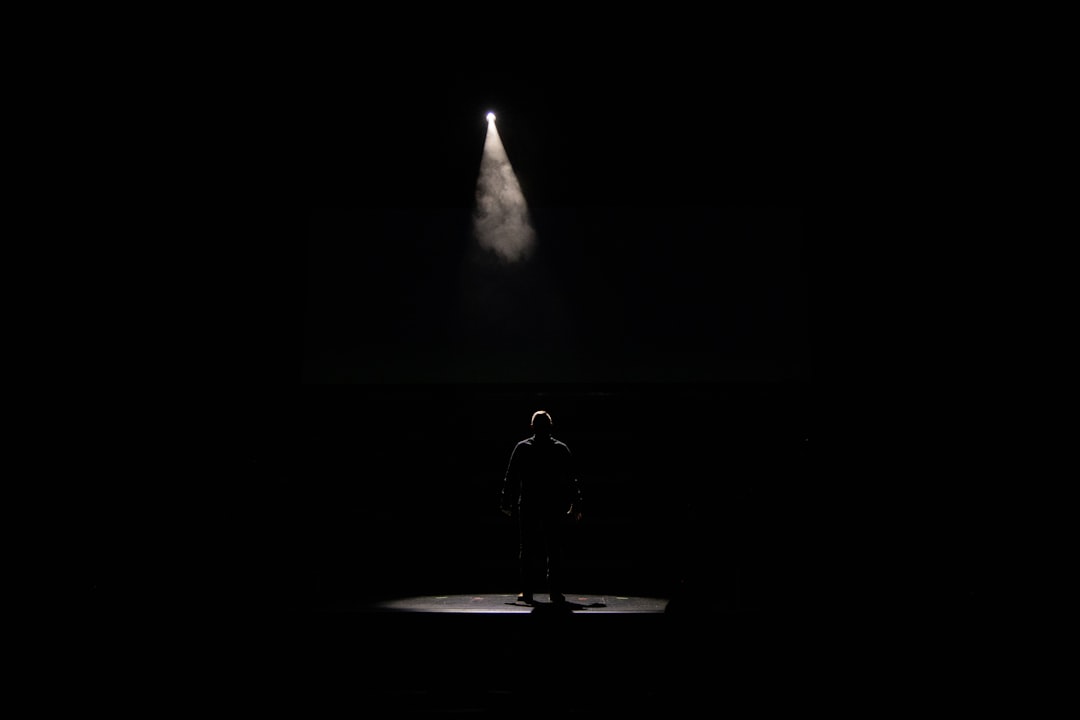 man in black jacket standing on the ground during night time