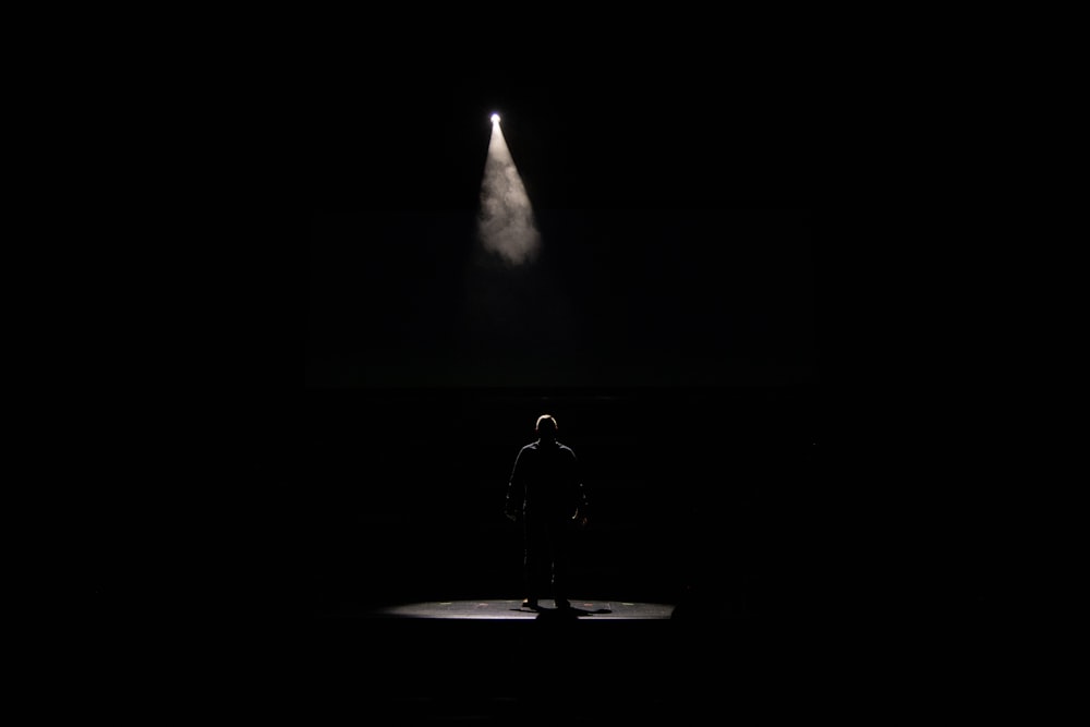 man in black jacket standing on the ground during night time