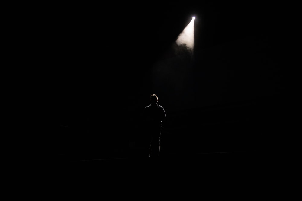 man in black jacket standing near light