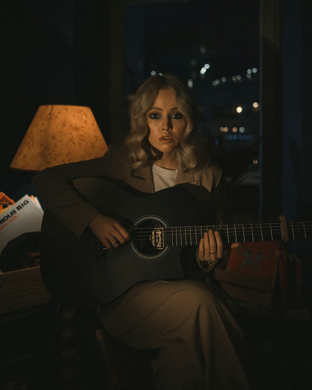 woman in black long sleeve shirt playing acoustic guitar