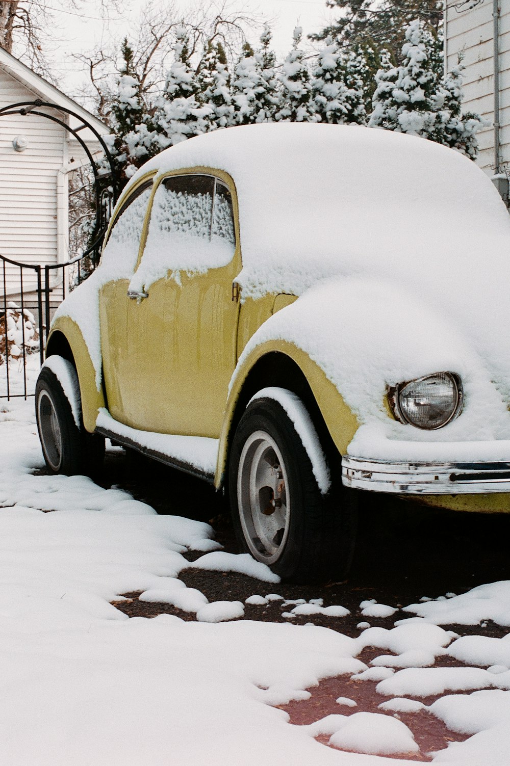 white and brown vintage car covered with snow