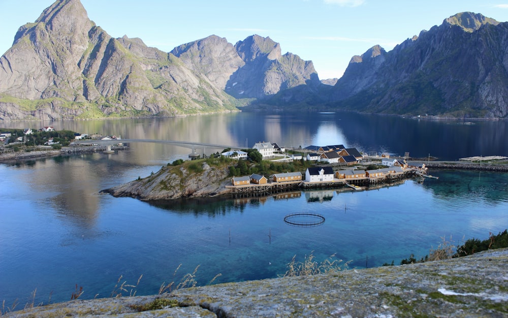 Braunes und weißes Haus in der Nähe von See und Bergkette