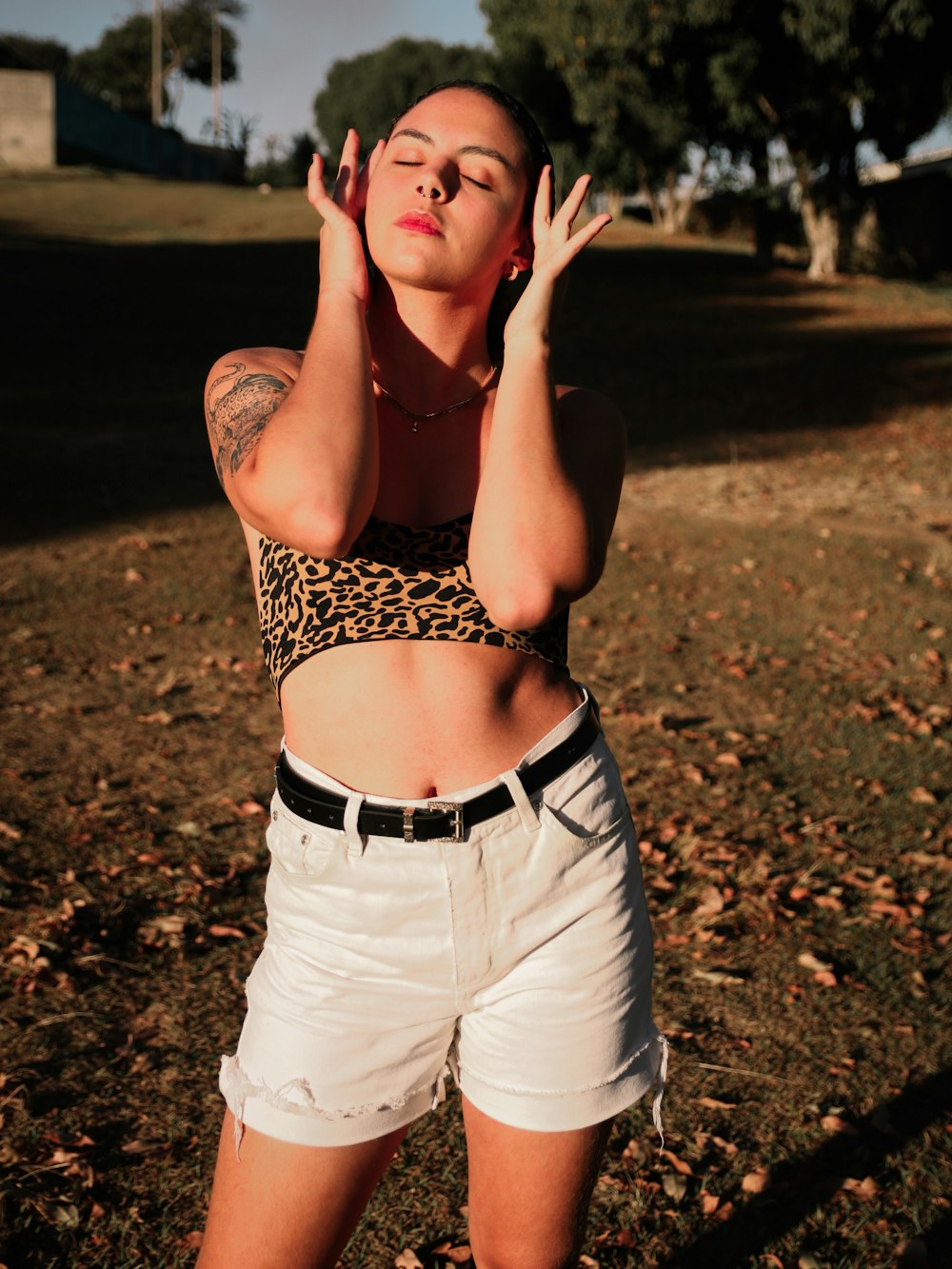 woman in black and brown leopard print tank top and white denim shorts