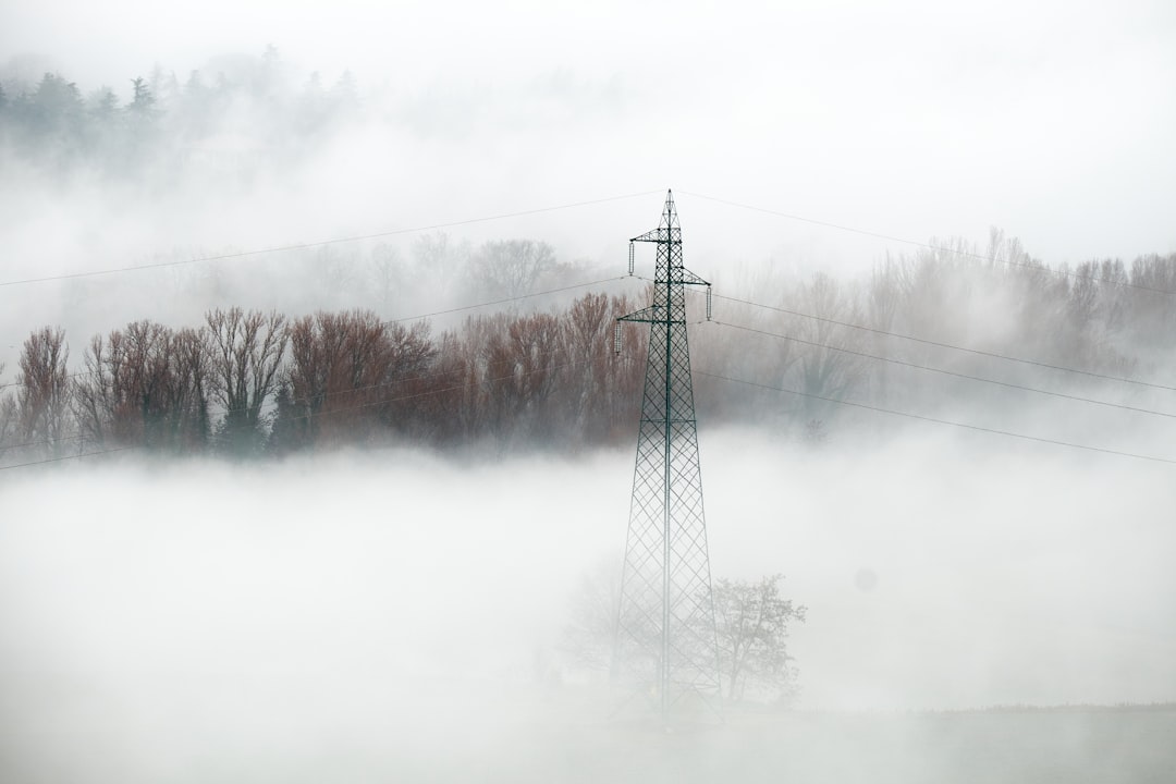 black electric tower on snow covered ground