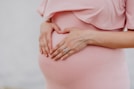 woman wearing gold ring and pink dress