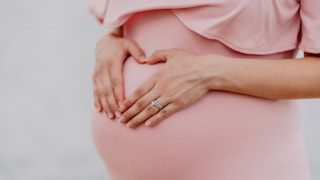 woman wearing gold ring and pink dress