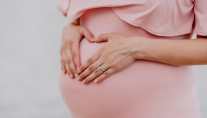 woman wearing gold ring and pink dress