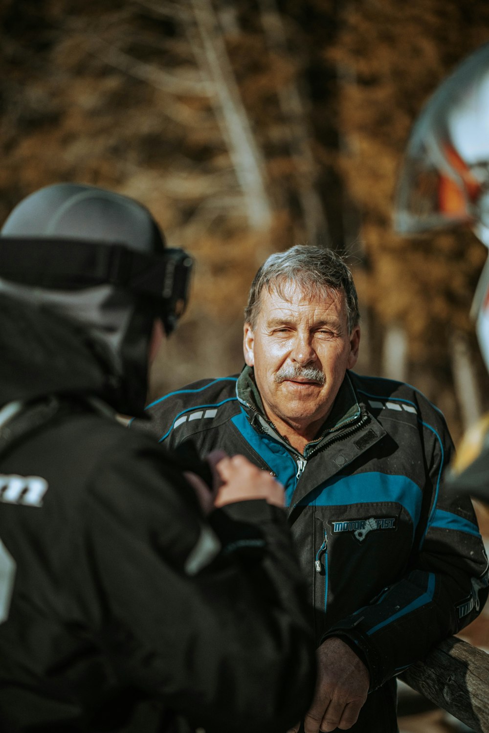 man in black and blue jacket smiling