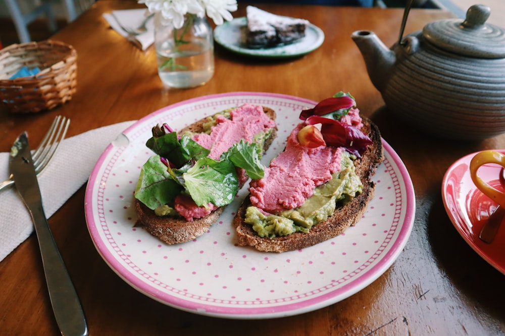 ham sandwich on pink and white round plate