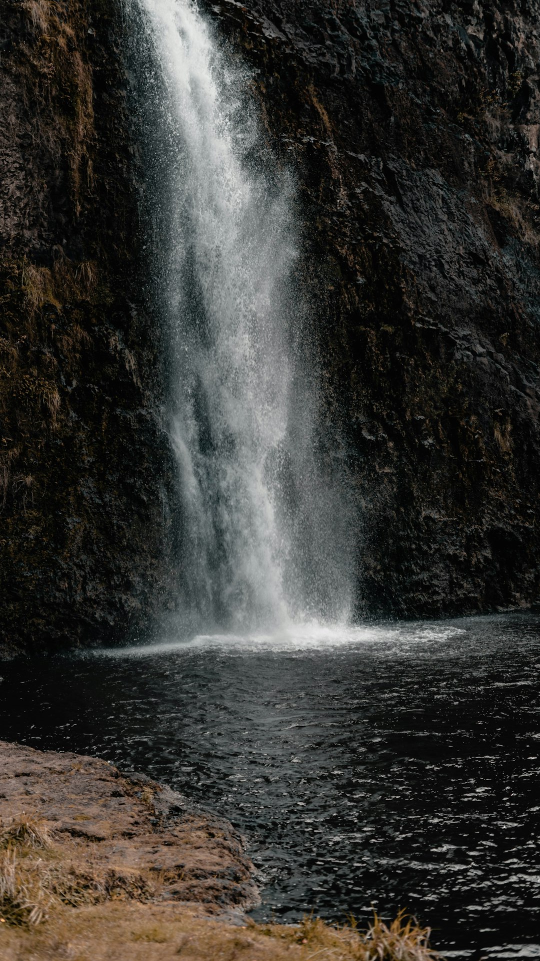 water falls on brown rocky mountain