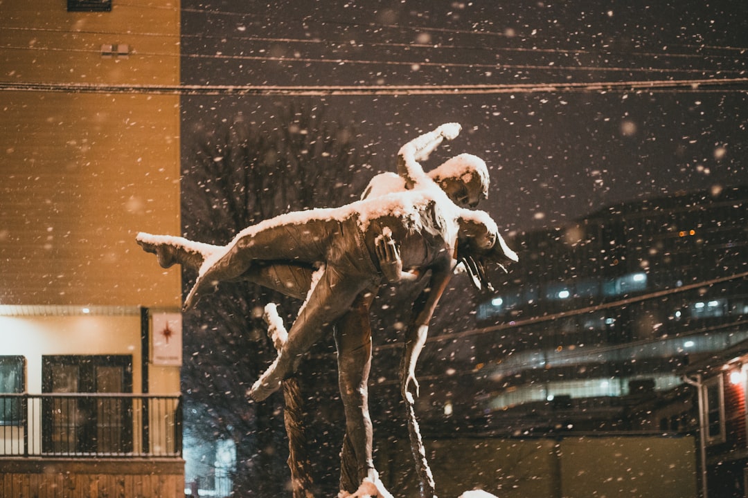 white angel statue in front of brown brick building