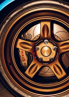 Minimalist shot of a luxury coupe’s wheel and brake detail with subtle bronze accents