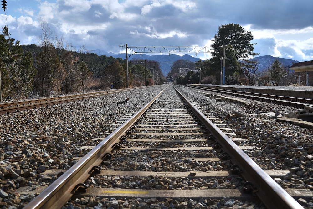 brown train rail under blue sky during daytime