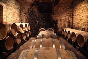 Cozy cellar interior with wooden barrels and dim lighting showcasing traditional Süryani wine storage.