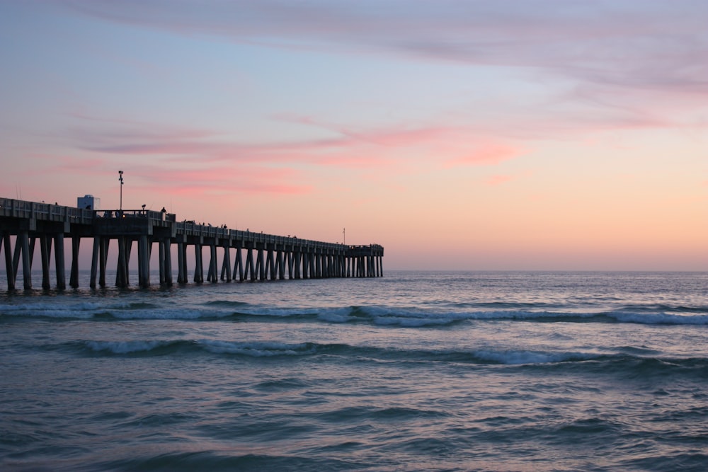 brown wooden dock on sea during sunset