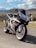 A smiling rider posing with a Ducati Multistrada against a scenic backdrop.