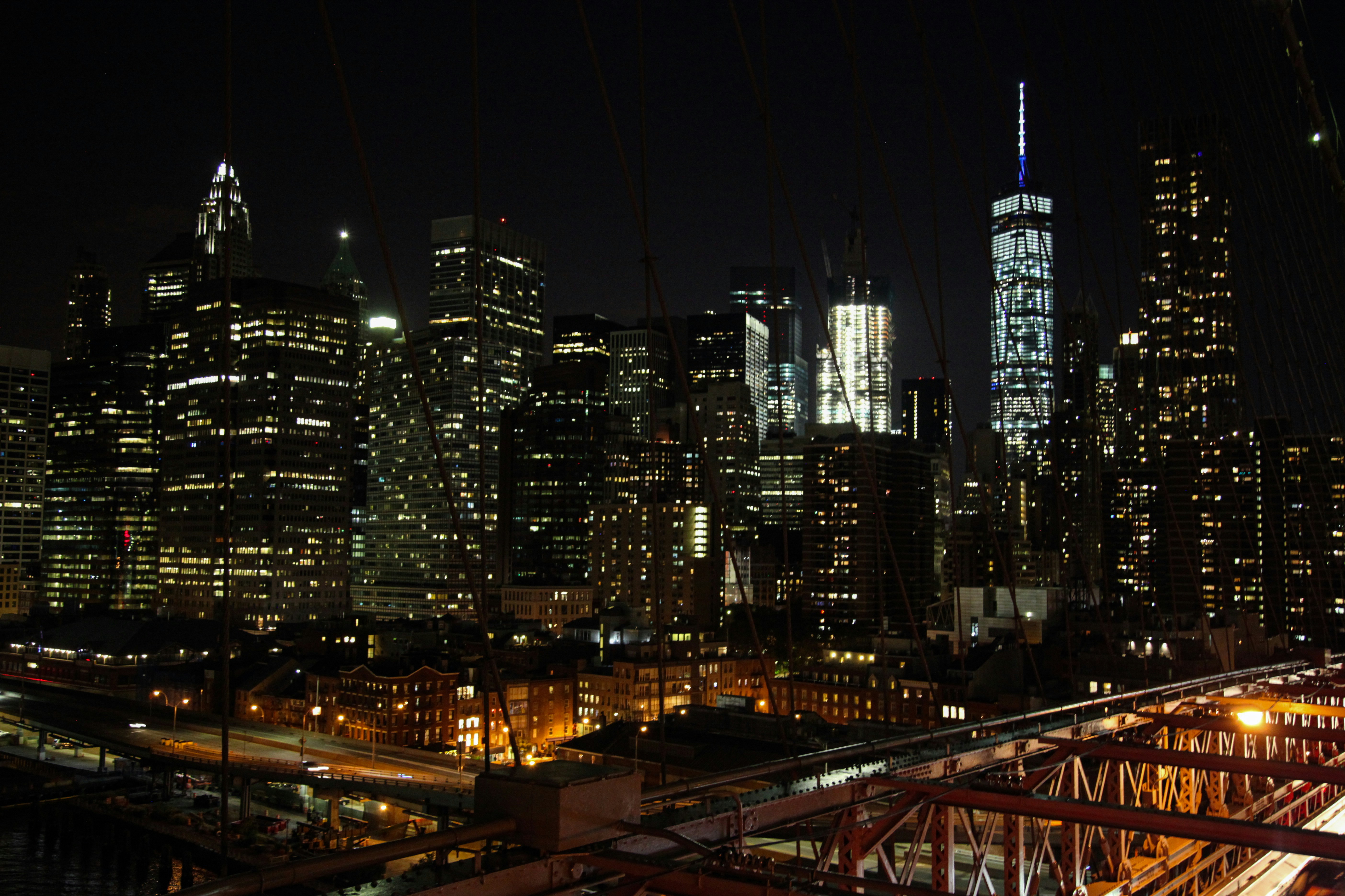 The Lower Manhattan skyline and the Brooklyn Bridge lit up at night