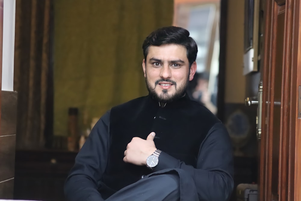 man in black sweater sitting on chair