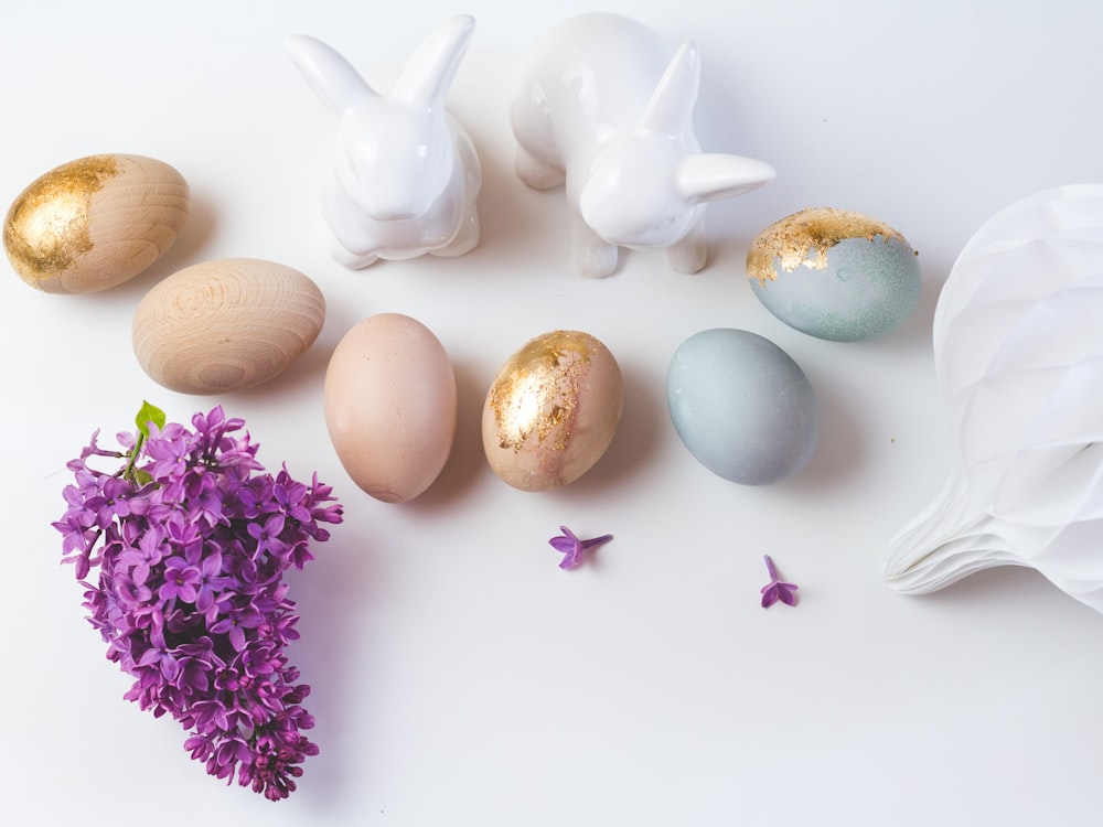 white ceramic rabbit figurine beside purple flowers