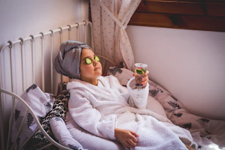 baby in white sweater and yellow goggles lying on bed