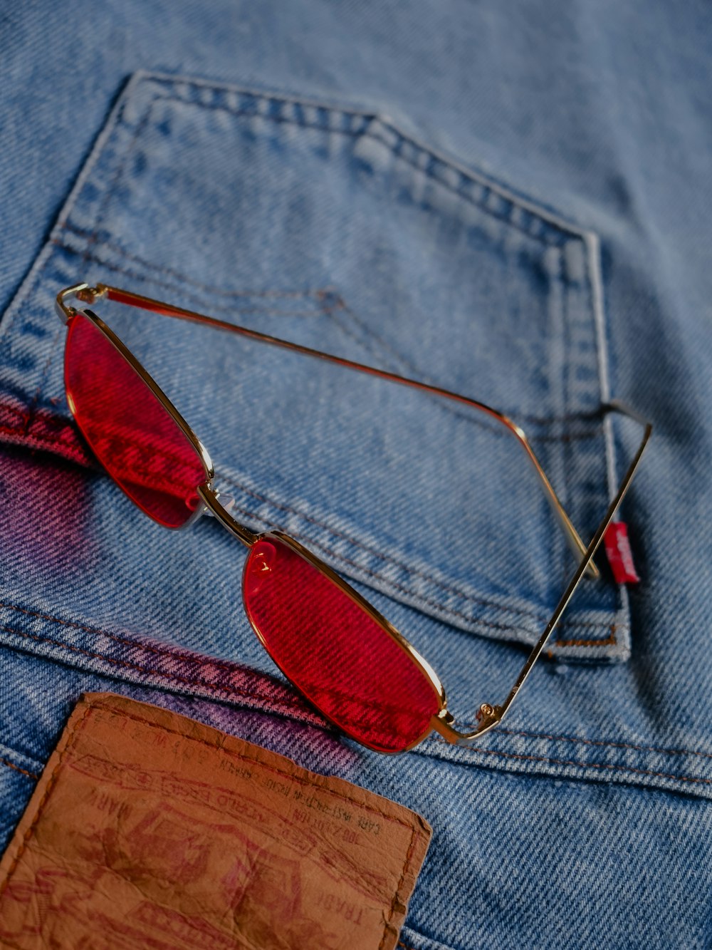 silver framed sunglasses on blue denim textile