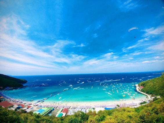 Vibrant photo of tourists enjoying parasailing over Bali’s turquoise waters on a sunny day.