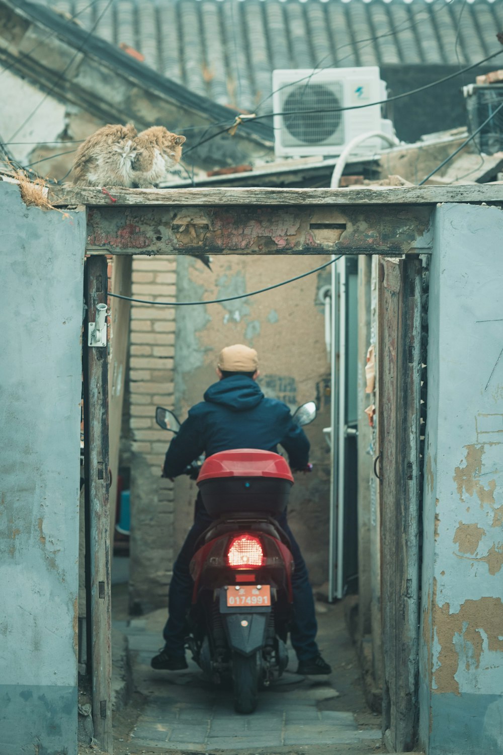 man in blue jacket and blue denim jeans sitting on red and black motorcycle during daytime