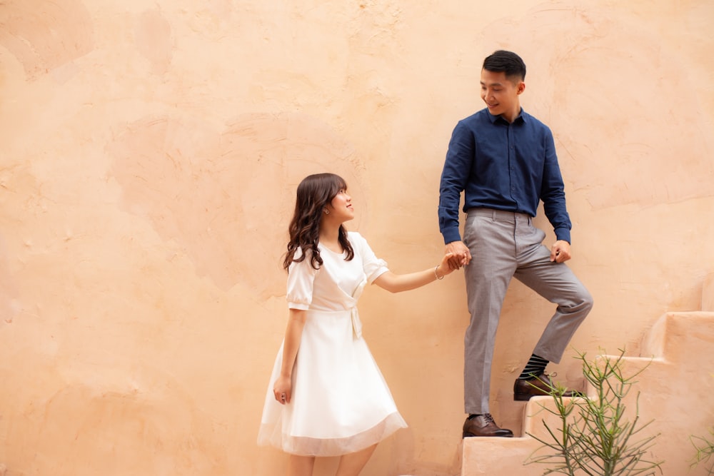 man in blue dress shirt and woman in white dress