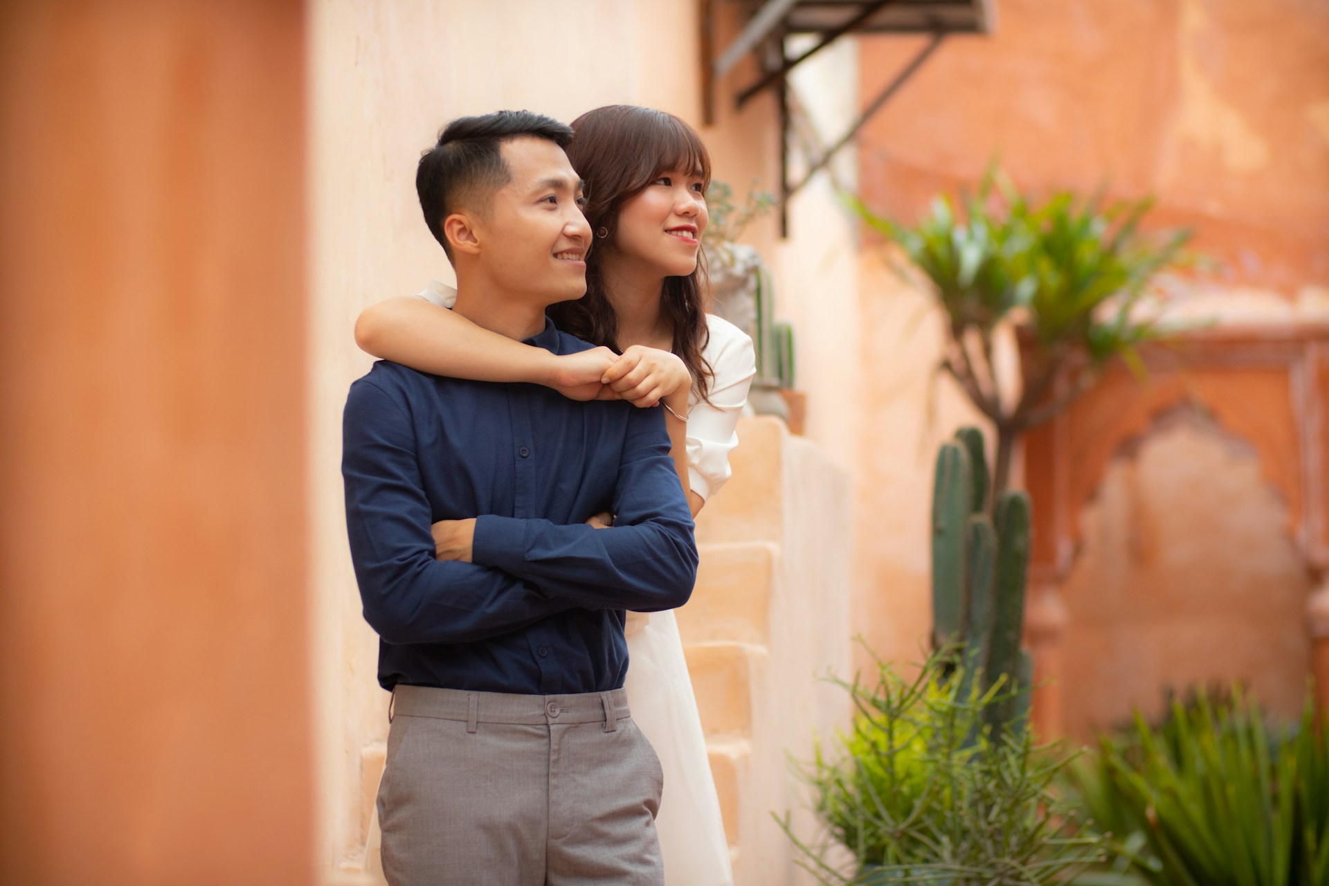 man in blue dress shirt and brown pants standing beside green plant during daytime