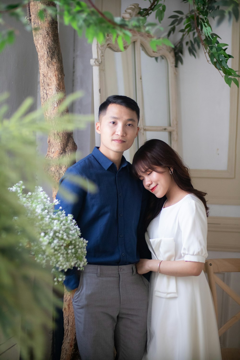 man in blue dress shirt standing beside woman in white dress