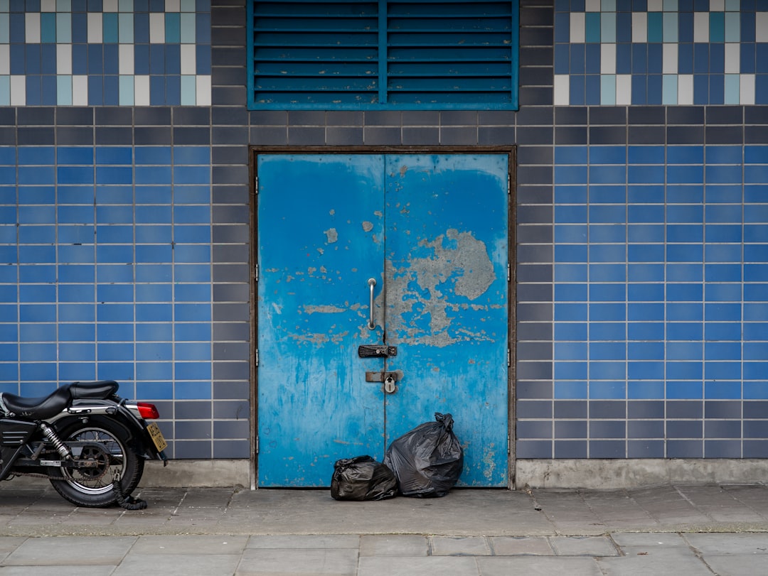 black motorcycle parked beside blue and white concrete building