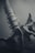 An artistic close-up of a skeletal structure, likely a human spine, with blurred segments that create a sense of depth. The monochromatic theme contributes to a somber and reflective mood.