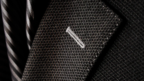 Close-up of a finely tailored blazer with intricate stitching and luxurious fabric texture.
