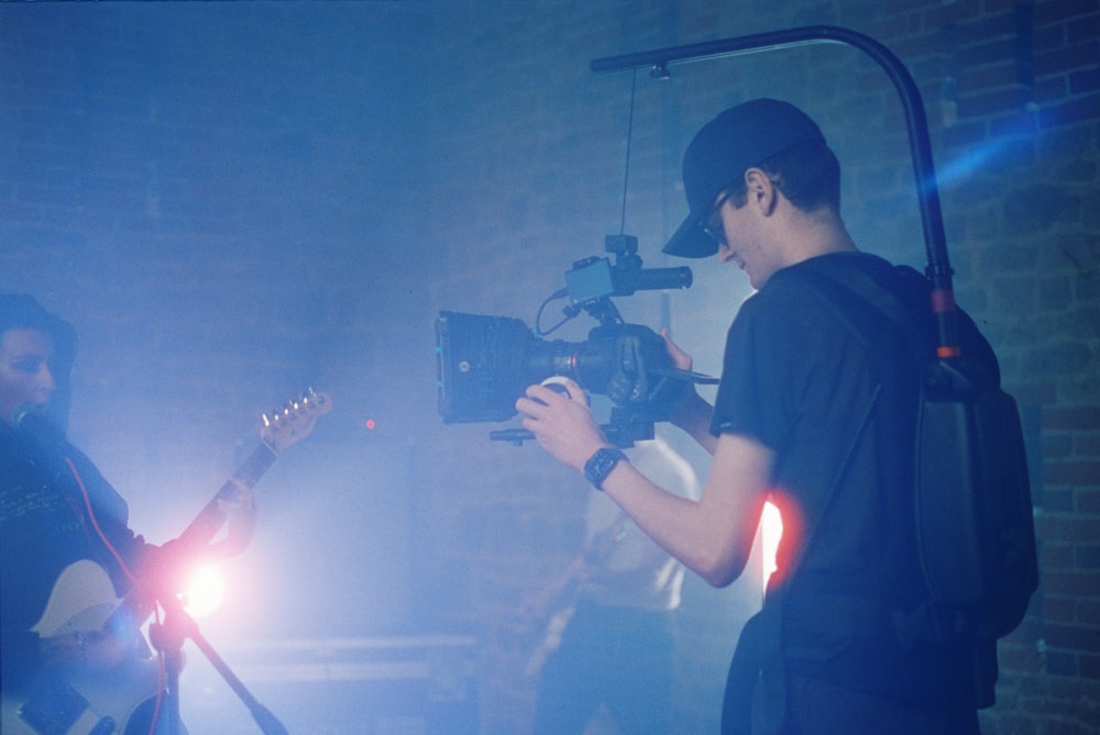 man in black t-shirt holding video camera