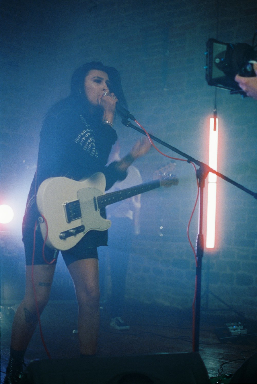 woman in black long sleeve shirt singing on stage