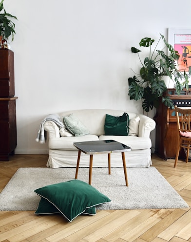 green throw pillow on white sofa