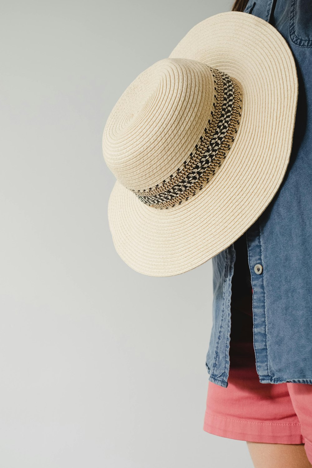person wearing brown straw hat and blue denim jacket