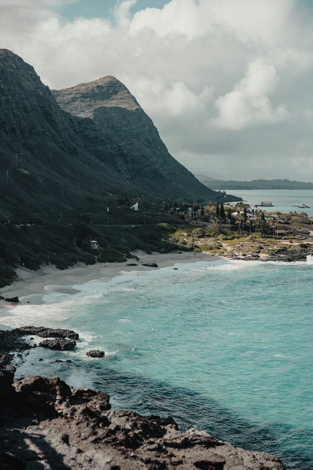 green and gray mountain beside body of water during daytime