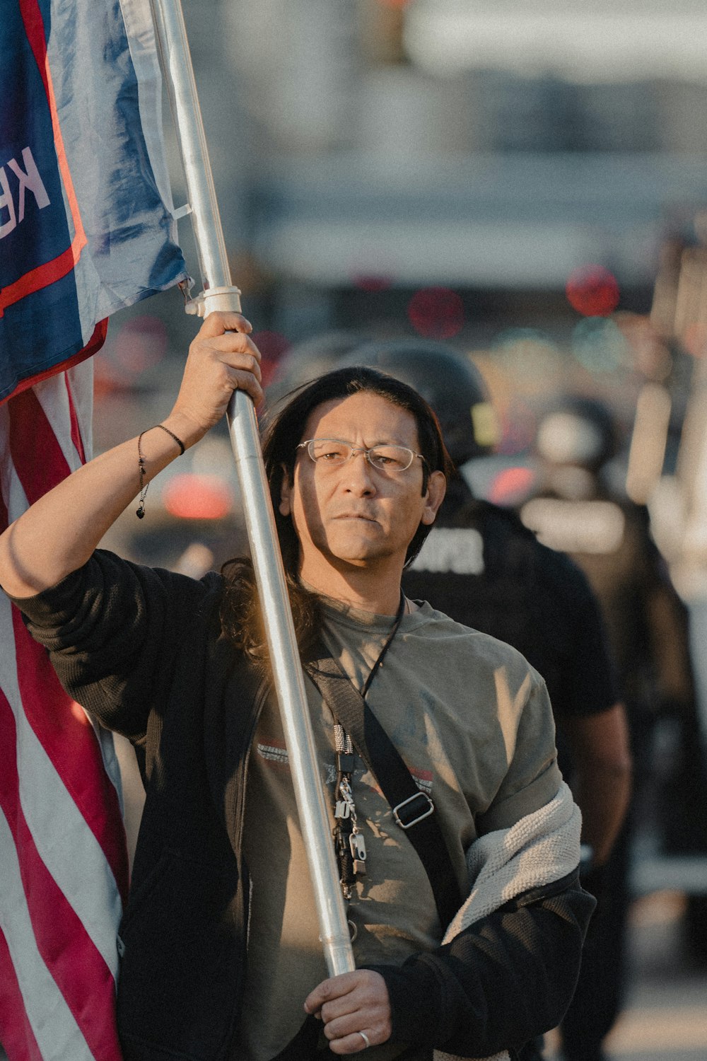 woman in brown shirt holding flag of us a during daytime