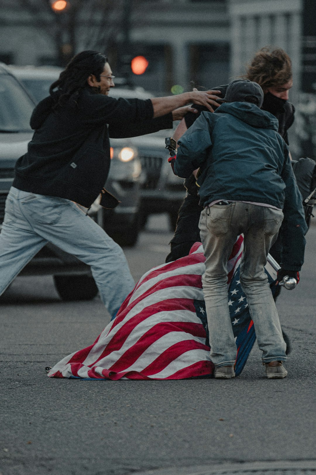 man in black jacket and gray pants holding us a flag