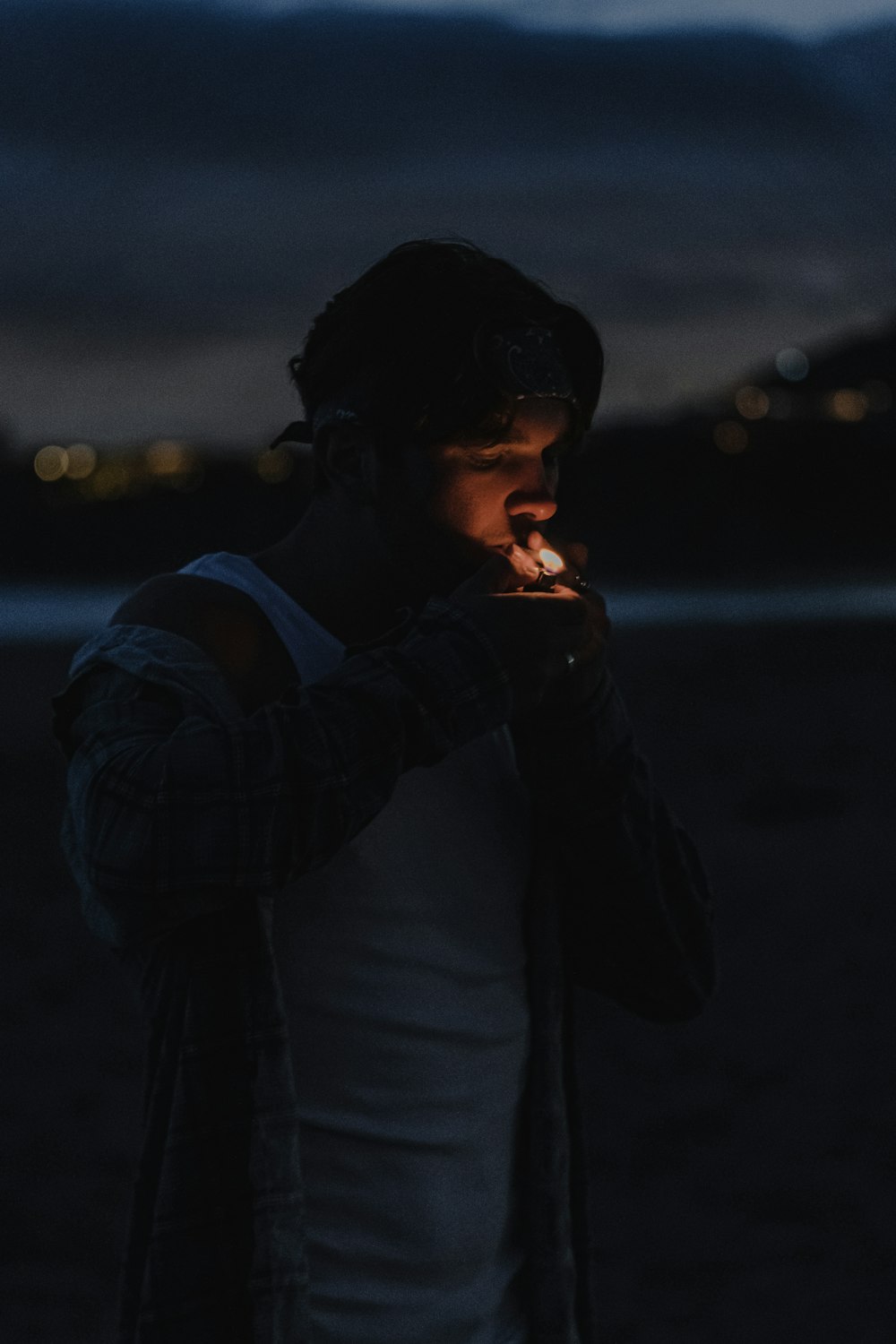 man in black jacket smoking cigarette during night time