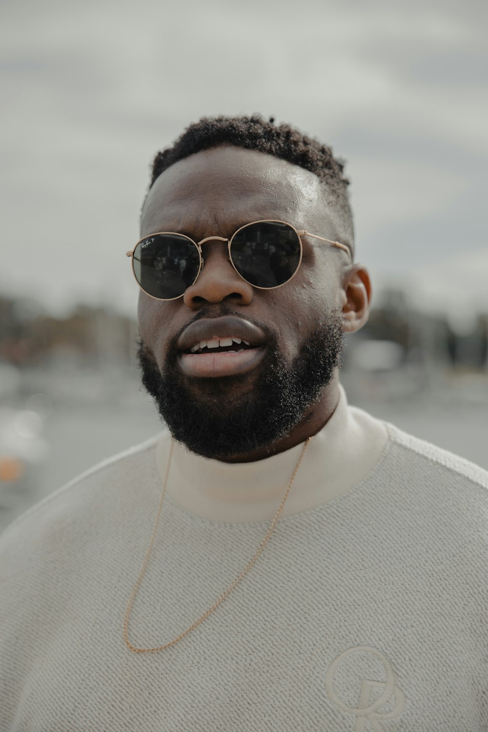 man in white turtleneck shirt wearing black sunglasses