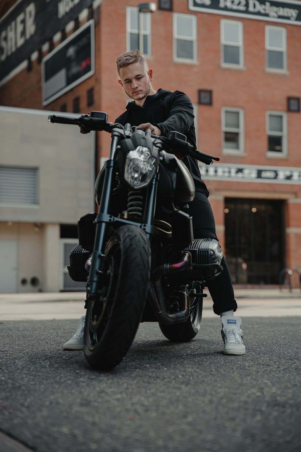man in black leather jacket riding black motorcycle during daytime