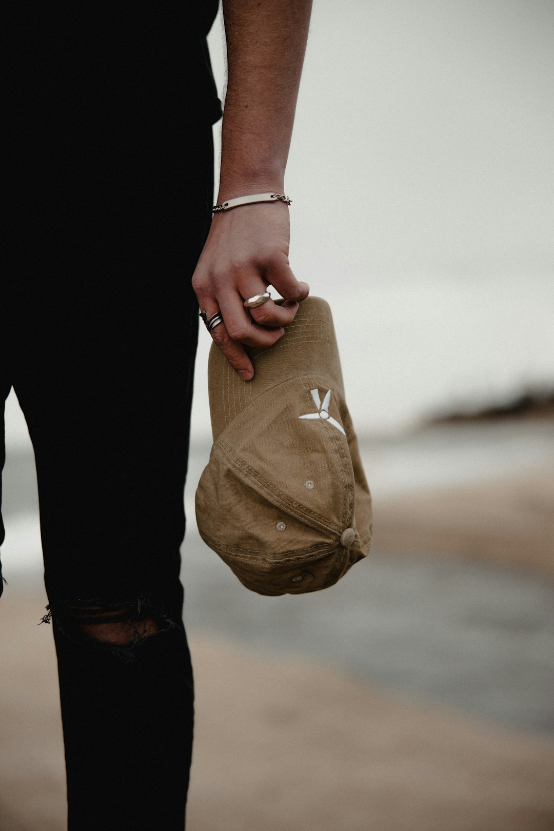 person in black pants holding brown paper bag