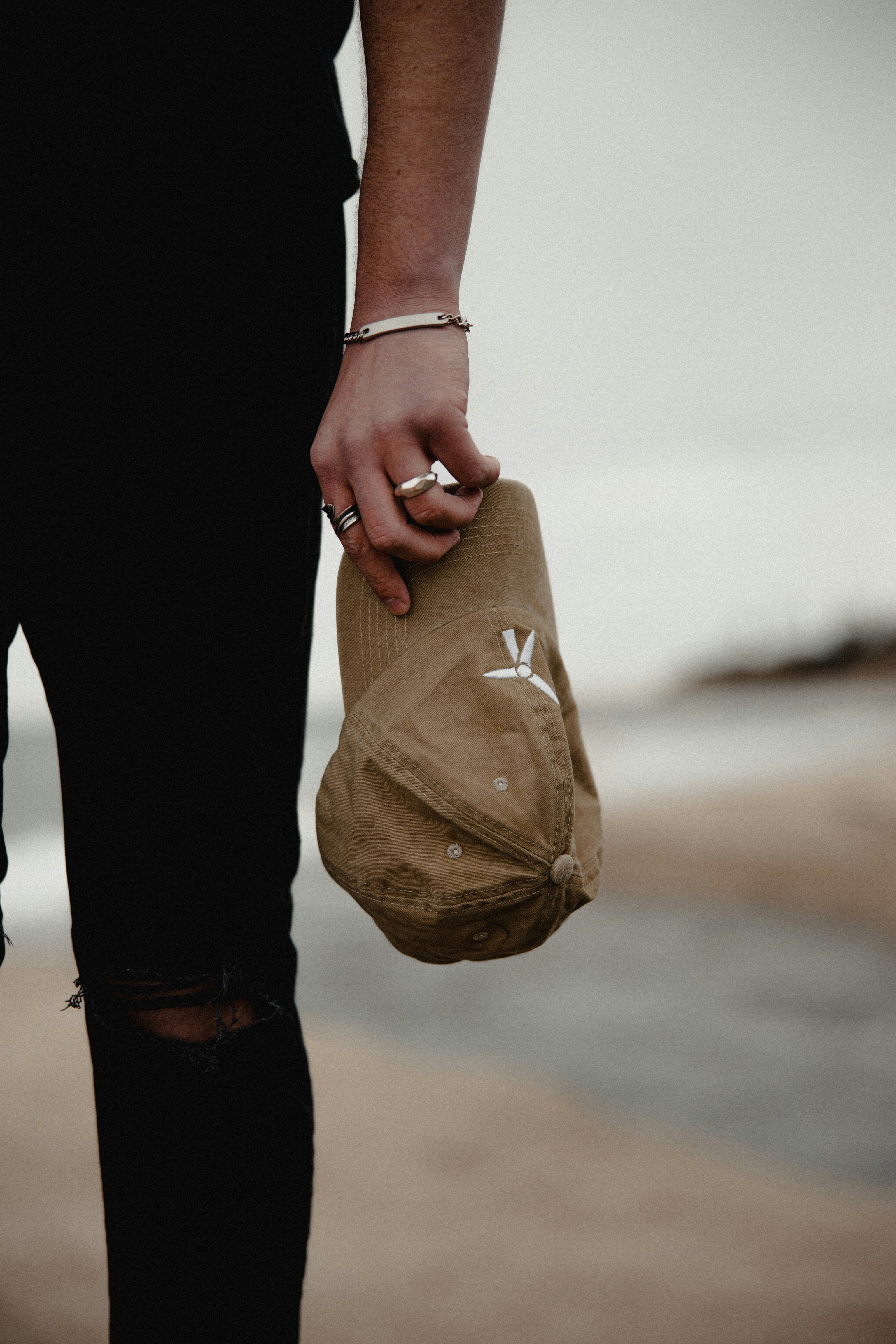 person in black pants holding brown paper bag