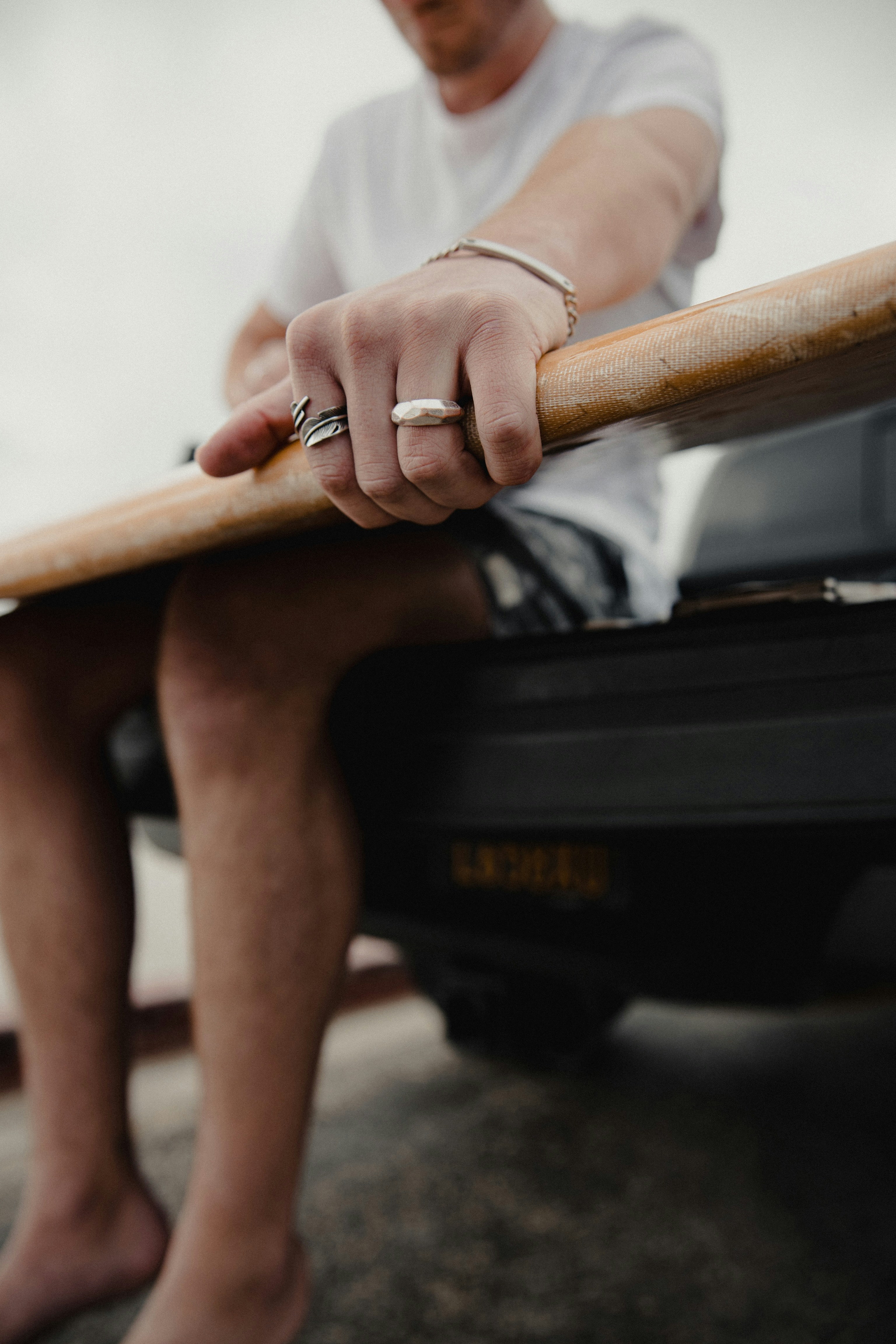 A person hanging from a wooden training bar