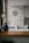 A kitchen interior featuring a modern design with a wooden countertop and a sleek sink. Wall decorations include a larger circular artwork and four smaller plates with artistic designs. An orchid plant and a decorative vase are placed near the window, adding a touch of elegance.